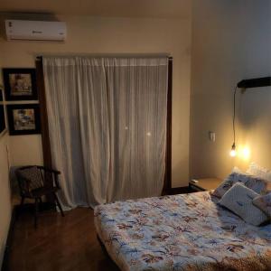尼泰罗伊Apartamento na quadra da Praia de Piratininga的一间卧室设有一张床和一个大窗户