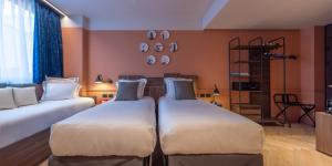 米兰Urban Hive Milano的一间客房配有两张床和一张沙发