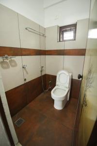 苏丹巴特利Wayanad Rooms Izza的一间带卫生间和玻璃淋浴间的浴室