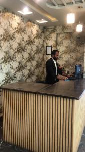木尔坦Hotel PAK Continental Multan的站在办公室柜台上的人