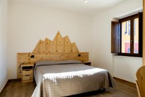 拉奎拉La Villetta Food & Drink Rooms for Rent - No Reception -的一间卧室配有一张带木制床头板的床
