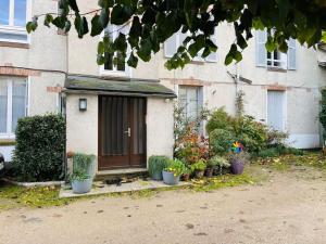 奥尔良Chaleureux appart, proche de La Loire avec parking的前面有盆栽的小房子
