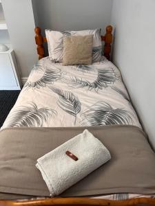 伦敦Home from Home Cosy B&B的一张带木制床头板和枕头的床