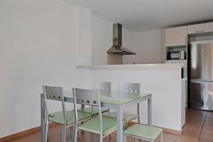 卡拉加尔达纳Prinsotel Villas Cala Galdana的厨房配有桌椅和冰箱。