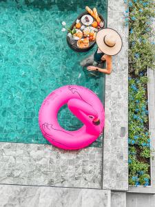 班怀雅Southern Peak Pool Villa Huay Yai Pattaya的水中粉红色火烈鸟的游泳池里的人