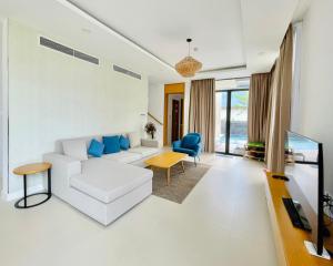 芽庄Cam Ranh Villa的客厅配有白色沙发和蓝色椅子