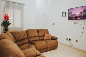 圣米格尔Moderna casa amueblada en residencial privada的客厅设有棕色沙发,配有平面电视