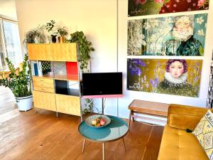 伯尔尼SONNEN Loft Bern - Bed & Breakfast的客厅配有电视和桌子