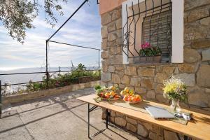 博尔迪盖拉Gli Orti sul mare 1的阳台上的桌子上放着水果