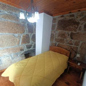 梅达Quinta das Amendoeiras的卧室配有一张石墙床