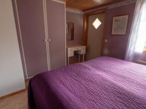 胡尔茨弗雷德Högerödja的一间卧室配有一张紫色的床和一张书桌