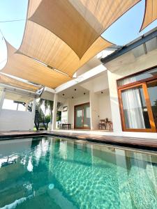 哈德超珊兰Chao Sam Ran Pool Villa Phetchaburi หาดเจ้าสำราญ เพชรบุรี ราคาสำหรับ 8 ท่าน的一座带遮阳篷和房屋的室内游泳池