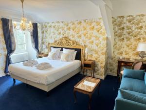舍内赫特勒斯图弗Chateau Le Prieuré Saumur - La Maison Younan的一间卧室配有一张床,铺有蓝色地板