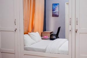 洛美Studio cosy climatisé的卧室配有白色的床和橙色窗帘