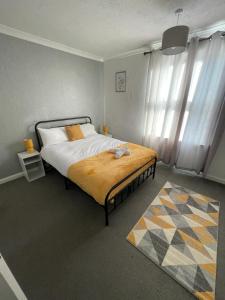 格兰瑟姆Contractor & Family House - Central Grantham的一间卧室配有一张黄色毯子床
