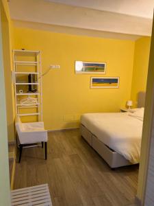 博洛尼亚Casa Francia Emilia Levante的黄色客房,配有床和椅子