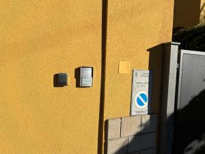 博洛尼亚Casa Francia Emilia Levante的黄色的墙,上面有两个电盒和标志