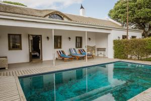 斯坦福Springfontein Wine Estate的一个带两把椅子的游泳池以及一座房子