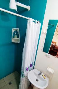 巴伦尼塔Buganvilla Guest House的浴室设有白色的淋浴帘和水槽