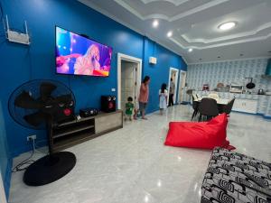 班康卡臣บ้านกลางหุบเขา แก่งกระจาน的客厅设有蓝色墙壁上的平面电视。