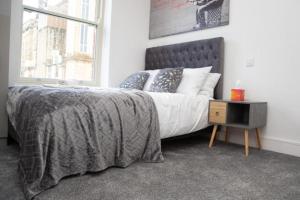 布莱克本OYO Hotel Rafay的一间卧室配有一张带灰色毯子的床和窗户。