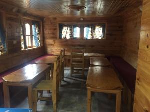 PhakdingTribeni Lodge Restaurant And Bar的小屋内带木桌和椅子的用餐室