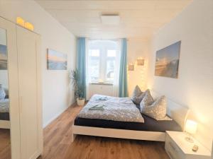 RathmannsdorfUrlaubsmagie - Helle Wohnung mit Garten & Pool - R3的一间卧室配有床和蓝色窗帘的窗户