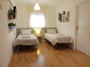 略夫雷加特河畔奥斯皮塔莱特bcn4days Apartments的客房设有两张床、一张桌子和一扇窗户。
