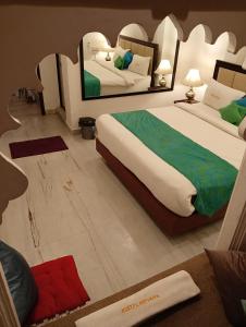 乌代浦Hostel Nirvana的一间卧室配有两张床和镜子