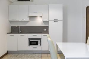 利莫内-苏尔加达Residence Oasi的白色的厨房配有水槽和微波炉