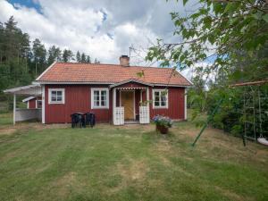 胡尔茨弗雷德Högerödja的一座红色的房子,在院子里设有门廊和椅子