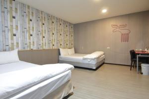 中坜宝山假期旅馆的客房设有两张床、一张桌子和一张书桌