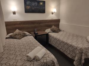 坦迪尔HOTEL ROMA DE TANDIL的酒店客房,配有两张带毛巾的床
