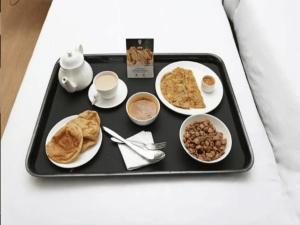 孟买HOTEL V.G的床上的早餐盘