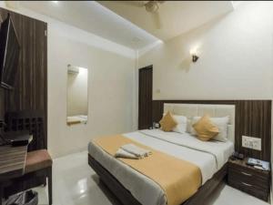 孟买HOTEL V.G的一间卧室配有一张大床和一张书桌