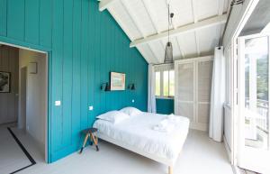 卡普费雷CABANE JASMIN au CAP FERRET的一间卧室设有蓝色的墙壁和一张床