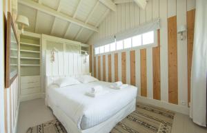 卡普费雷CABANE JASMIN au CAP FERRET的卧室配有白色的床和窗户。