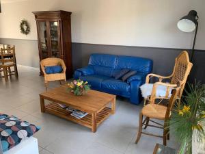 阿雷斯VILLA CARO à ARES - BASSIN D'ARCACHON的客厅配有蓝色的沙发和椅子