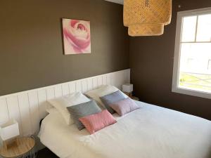 阿雷斯VILLA CARO à ARES - BASSIN D'ARCACHON的卧室内的一张带三个枕头的床