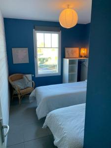 阿雷斯VILLA CARO à ARES - BASSIN D'ARCACHON的蓝色的客房设有两张床和窗户。