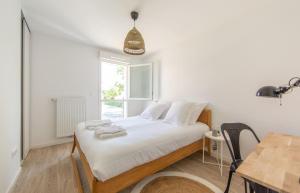 安德诺莱斯贝恩APPARTEMENT Des Verdiers的一间卧室配有一张床、一张桌子和一个窗户。