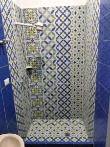 波帕扬Lienzo Hostel and Mural Art Museum的浴室的墙壁上铺有蓝色和白色的瓷砖。