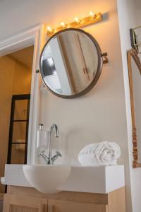 塞维利亚The Honest Hotel的浴室水槽和墙上的镜子