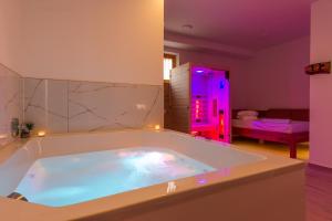 马里博尔Vilaraj的浴室内设有一个大浴缸及紫色灯