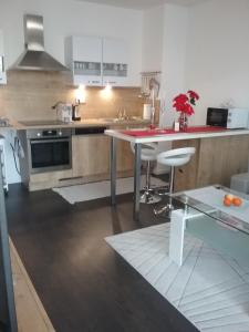 班斯卡-比斯特里察2 izbový luxusný apartmán v novostavbe v centre mesta的厨房配有桌子和红色台面