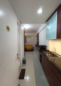 TekoHariss Inn Bandara的一个带水槽的厨房和一张位于客房内的床