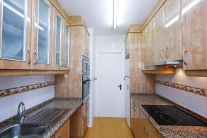 维拉福林New Reus Mediterrani的一个带木制橱柜和水槽的厨房