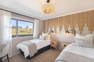 布鲁堡史特兰Coral Island 204的一间卧室设有两张床和窗户。