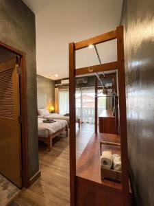 清迈BOSS HOTEL CHIANGMAl的客房设有带一张床和镜子的卧室