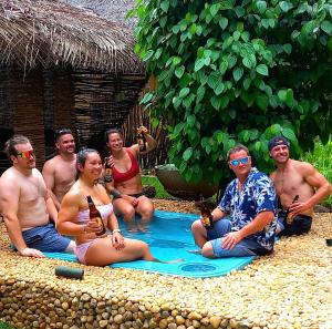 达瓦拉维Atha Safari Resort & Riverside Camping的一群人坐在游泳池里